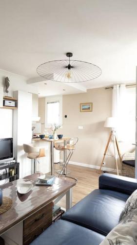 un salon avec un canapé bleu et une table dans l'établissement L'Echo des Vagues, Appartement 2p, 50m de la plage, à Villers-sur-Mer