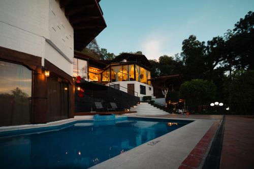 una casa con piscina frente a una casa en BOTANIQ HOTEL BOUTIQUE en Valle de Bravo