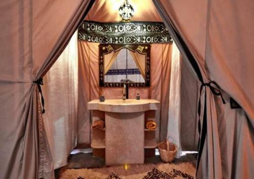 a bathroom with a sink in a tent at Shiny luxury camp in Merzouga