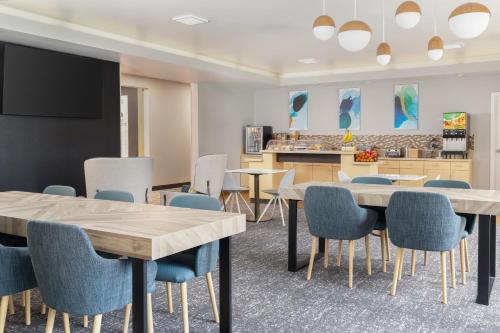 Una sala de espera con mesas y sillas y un televisor. en TownePlace Suites by Marriott Sacramento Roseville, en Roseville