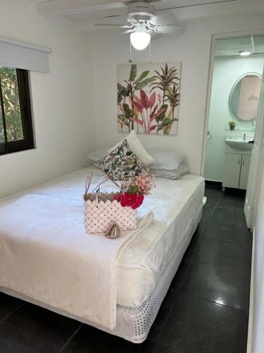 a bedroom with a bed with a basket of flowers on it at Guest house in Altos del Maria in Sorá