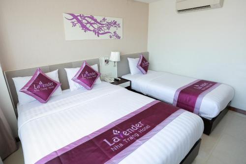 two beds sitting next to each other in a room at Lavender Nha Trang Hotel in Nha Trang