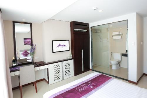 a bathroom with a toilet and a desk and a sink at Lavender Nha Trang Hotel in Nha Trang