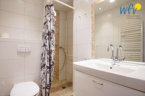 a bathroom with a sink and a toilet and a shower at Ferienhaus Seeblick - Wohnung 96 in Borkum