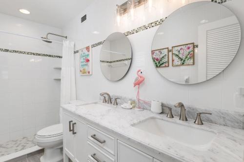 a bathroom with a sink and two mirrors at Breakers West C2 - Gorgeous Top Floor Beach Condo in Sanibel