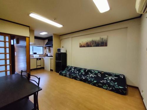 a living room with a couch and a kitchen at 2 min from NANBA 16 min from USJ by train in Osaka