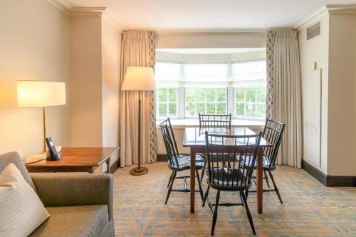 a living room with a table and chairs and a couch at Williamsburg Lodge, Autograph Collection in Williamsburg