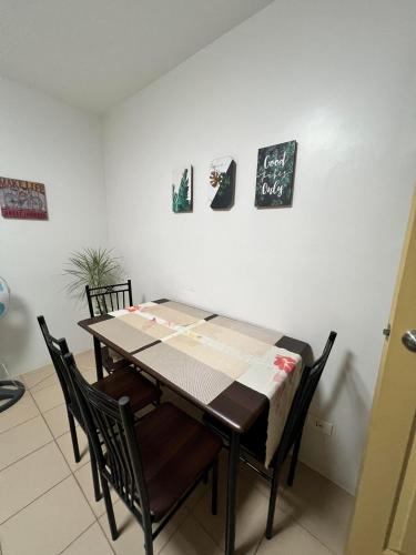 a dining room with a table with chairs and a chalkboard at Sunsets and Good Vibes - 2 Bedroom Condo Unit in Iloilo City