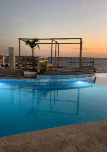 una piscina junto al océano al atardecer en Residencia altamar 1 habitación, en Boca Chica
