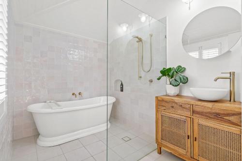 une salle de bain avec une baignoire, un lavabo et un miroir dans l'établissement 34 Woodburn Street, à Evans Head