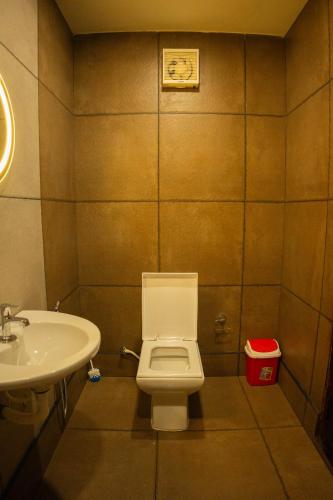 a bathroom with a toilet and a sink at Why Not Houseboat in Alleppey