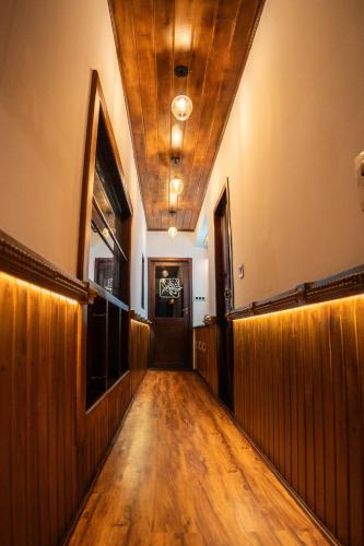 a hallway with a wooden floor and a door at Why Not Houseboat in Alleppey