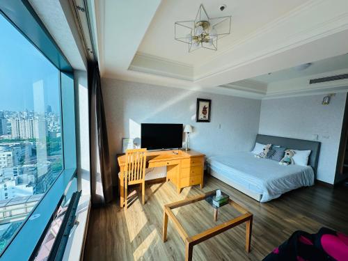 a bedroom with a bed and a desk with a television at Luxury House in Taichung