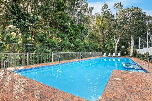 a large blue swimming pool in a yard at Pacific Towers Beach Resort in Coffs Harbour