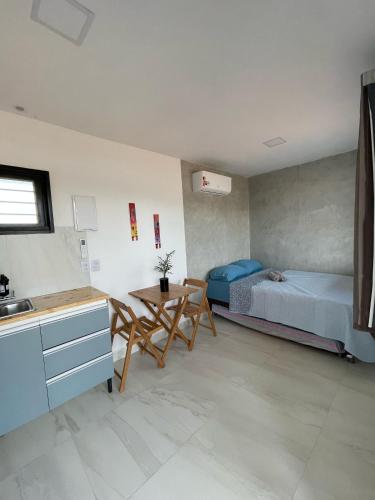 een keuken en een slaapkamer met 2 bedden en een tafel bij Suíte Contêiner Roraima in Boa Vista