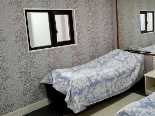 a bedroom with two beds and a window at Quba ALFA-M Motel in Quba
