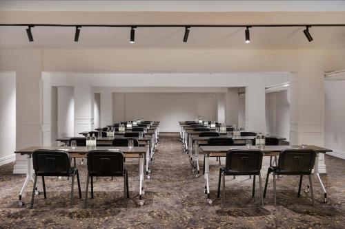 an empty room with rows of tables and chairs at Fable Auckland, MGallery in Auckland