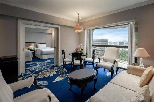 a living room with a couch and a room with a bedroom at Sari Pacific Jakarta, Autograph Collection in Jakarta