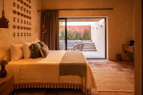 Comala的住宿－La Paranera Hotel & Relax，一间卧室设有一张床,并有通往庭院的门