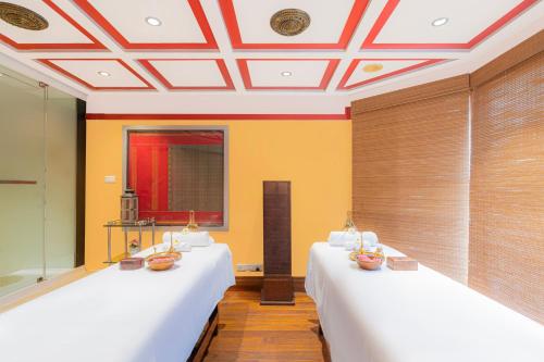 two beds in a room with yellow walls at Hyderabad Marriott Hotel & Convention Centre in Hyderabad