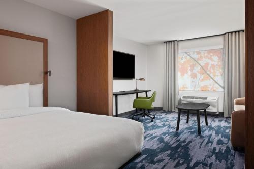 a hotel room with a bed and a desk and a television at Fairfield by Marriott Inn & Suites Chino in Chino