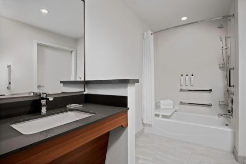 a bathroom with a sink and a bath tub at Fairfield by Marriott Inn & Suites Chino in Chino