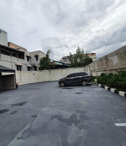 een zwarte auto geparkeerd op een parkeerplaats bij Cut Nyak Dien Guest House in Lampung