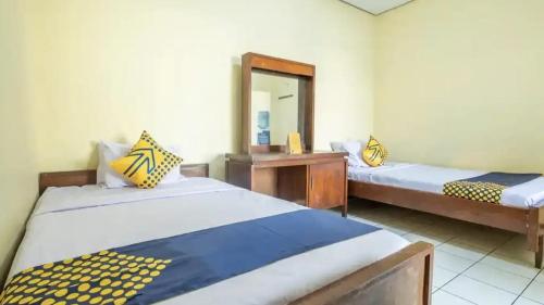 a room with two beds and a mirror at Cut Nyak Dien Guest House in Lampung