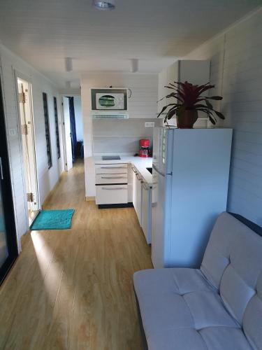 a kitchen with a white refrigerator and a couch at Les Maripas T2 in Rémiré
