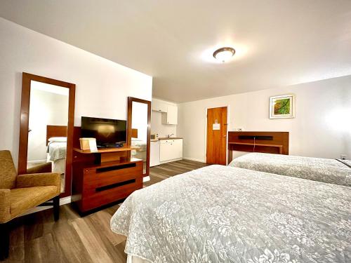 Budget Inn في Wellsville: غرفه فندقيه سريرين وتلفزيون