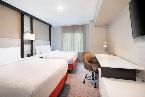 a hotel room with two beds and a desk at Springhill Suites by Marriott Conyers in Conyers