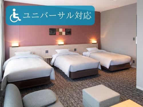 a hotel room with three beds and a sign at Kotohira Park Hotel in Kotohira