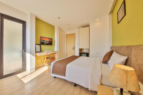 a bedroom with a bed and a desk in it at Daisy Flower Nha Trang in Nha Trang