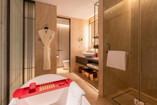 a bathroom with a white bath tub and a shower at HUALUXE Beijing Xinan in Beijing