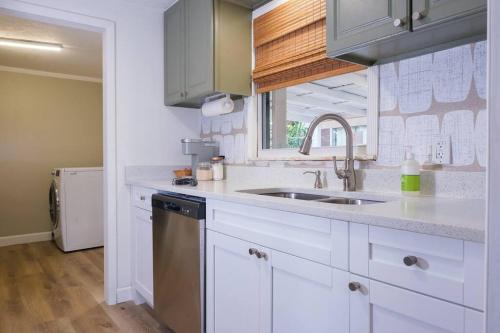 a kitchen with white cabinets and a sink at House near Tampa Zoo and Busch Gardens, free high speed wifi in Tampa