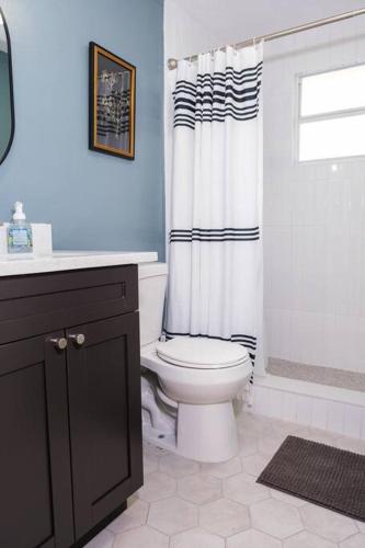 a bathroom with a toilet and a shower curtain at House near Tampa Zoo and Busch Gardens, free high speed wifi in Tampa
