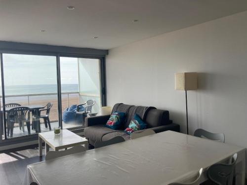un salon avec un canapé et une table dans l'établissement Appartement moderne 2 chambres avec balcon face mer, WiFi et parking à Saint-Jean-de-Monts - FR-1-323-117, à Saint-Jean-de-Monts