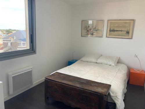 - une chambre avec un lit et une table en bois dans l'établissement Appartement moderne 2 chambres avec balcon face mer, WiFi et parking à Saint-Jean-de-Monts - FR-1-323-117, à Saint-Jean-de-Monts