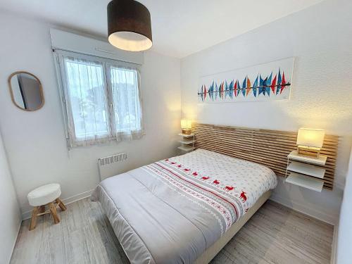 een slaapkamer met een bed, 2 lampen en een raam bij Appartement Jullouville, 2 pièces, 4 personnes - FR-1-361-45 in Jullouville-les-Pins