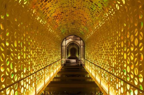 a tunnel covered in gold lights and stairs at W Osaka in Osaka