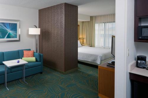 une chambre d'hôtel avec un canapé et un lit dans l'établissement SpringHill Suites by Marriott Lansing, à Lansing