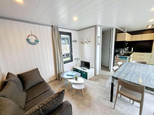 un salon avec un canapé et une table dans l'établissement Chalet haut de gamme - 6 pers - Piscine chauffée - Proche plage - Jullouville - FR-1-361-518, à Jullouville