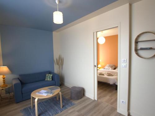 een woonkamer met een blauwe bank en een bed bij Appartement Chazelles-sur-Lyon, 2 pièces, 2 personnes - FR-1-496-298 in Chazelles-sur-Lyon