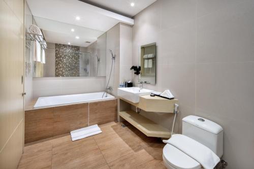 uma casa de banho com uma banheira, um WC e um lavatório. em Four Star by Trans Hotel em Sanur