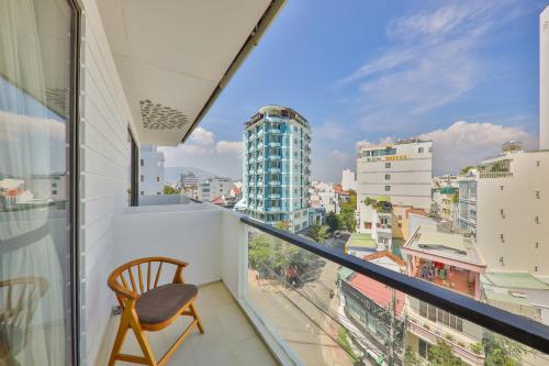 a chair on a balcony with a view of a city at Daisy Flower Nha Trang in Nha Trang