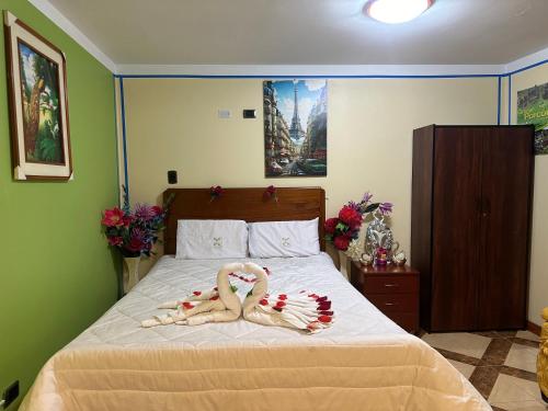 two people in towels laying on a bed at Hotel Elegant in Cajamarca