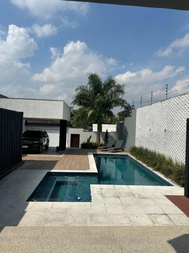 una piscina frente a un edificio blanco en Casa Conteiner, en Itaboraí