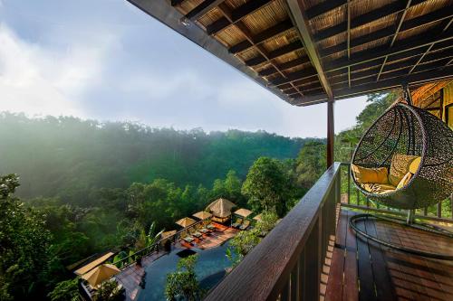 einen Außenbalkon mit Hängematte und ein Resort in der Unterkunft Nandini Jungle by Hanging Gardens in Payangan
