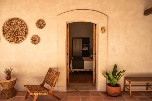 een deur naar een kamer met een stoel en een slaapkamer bij La Paranera Hotel & Relax in Comala