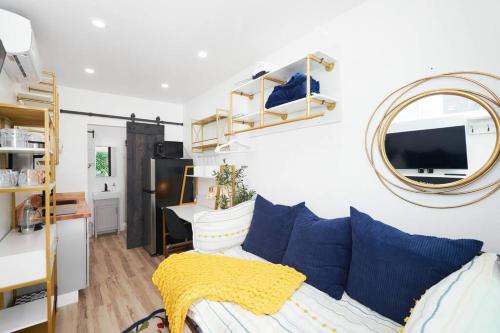 a living room with a couch and a mirror at Tiny Living; Big Style in Oakland